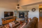 The living area features a cozy gas fireplace and flat screen TV for entertainment